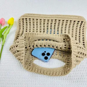 Vue détaillée d'un sac tote beige en tricot ajouré, idéal pour une journée à la plage.