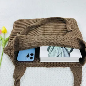 Vista dettagliata della borsa tote in maglia marrone scuro con interno spazioso e morbido.