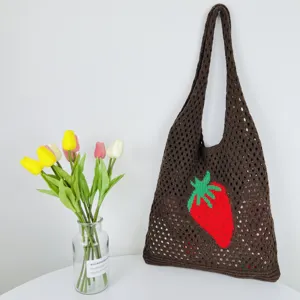 Nahaufnahme der braunen Häkel-Tasche mit rotem Erdbeermuster und luftigem Lochmuster.