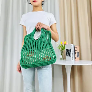 Détail de sac cabas en crochet vert, design ajouré tissé pour la plage et l'usage quotidien.