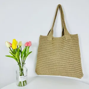 Vista dettagliata di una borsa tote in maglia casual kaki, con un design retrò capiente.
