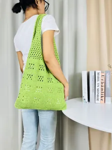 Detailansicht der grünen Häkel-Schultertasche mit Lochmuster, feines Netz-Strickdesign.