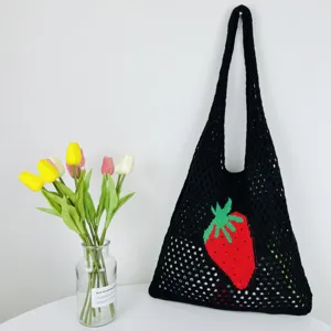 Detailansicht des schwarzen gehäkelten Shoppers mit einem roten Erdbeermuster im tollen Detail.