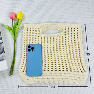 Vue détaillée du sac cabas fourre-tout tricoté beige élégant, parfait pour la plage.