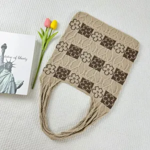 Detailed shot of a knitted floral tote bag in beige and brown with a spacious design.