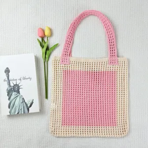 Nahaufnahme der rosa-beigen Häkel-Strick-Tasche, stilvolle Netz-Strandtasche Detail.
