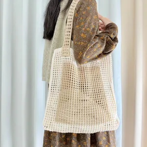 Detailaufnahme einer schicken gehäkelten Beuteltasche in Beige für den perfekten Sommer.