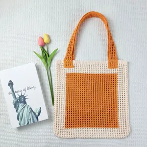 Detailaufnahme der beigen und orangen Häkel-Netztasche mit bequemen Strick-Schulterriemen.