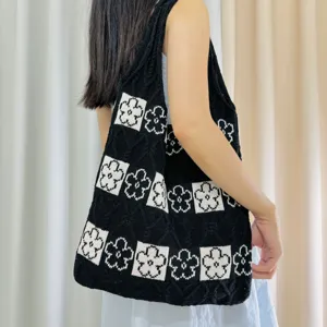 Black knit tote bag featuring white floral patterns and large capacity for daily use.