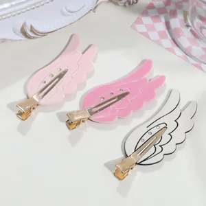 Detail view of sweet angel wings duckbill hair clips set in pink and white colors.