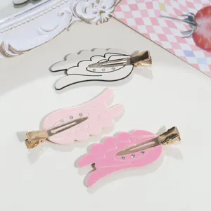 Detail view of sweet angel wing duckbill hair clips in white and pink, cute side hair styling.