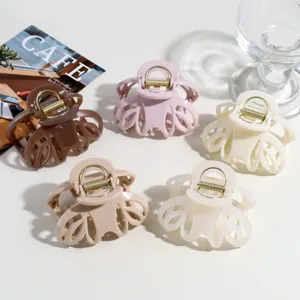 Detailed close-up of hollow pumpkin hair claw clips in assorted chic colors with metal spring.