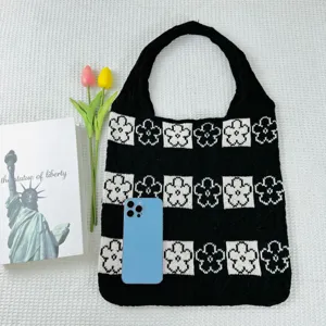 Detailed view of the black and white knitted floral tote bag showcasing the intricate woven pattern and texture.