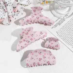 Detailaufnahme rosa blumiger Haarklammern, verschiedene Minigrößen für schickes Styling.