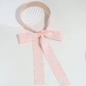 Primer plano detallado de la elegante diadema de encaje rosa con un bonito lazo y cintas.