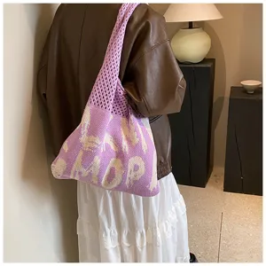 Detailansicht der lila gestrickten Umhängetasche mit Buchstabenmuster und großem Fassungsvermögen.