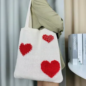 Schicke weiße Strick-Tasche mit roten Herzmustern und Perlen für den modischen Alltagslook.