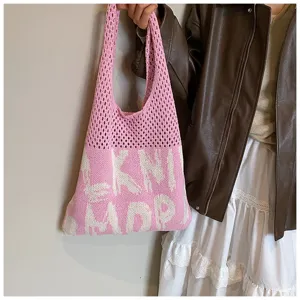 Detailaufnahme der rosa Strick-Tragetasche mit weichem Schulterriemen und lässigem Design.