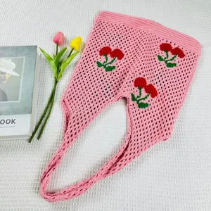 Vista detallada de un bolso de malla tejido en rosa con diseño de cerezas y gran capacidad.