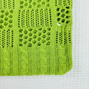 Nahaufnahme der grünen Strick-Taschentextur, Lochmuster-Design, lässige Sommer-Strand-Stildetails.