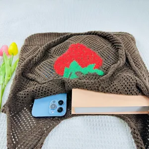 Detailaufnahme der gestrickten Erdbeer-Tasche, braune Netztasche im Nahbereich.