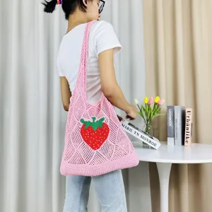 Detailansicht einer hübschen rosa Häkel-Tragetasche mit einem auffälligen Erdbeer-Muster.