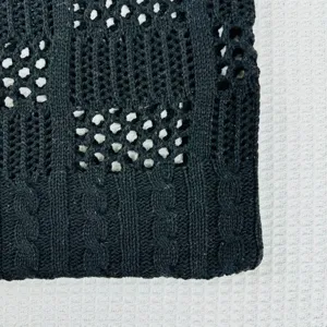 Detailansicht der schwarzen Strick-Tasche mit stilvollem Lochmuster für Strand und Freizeit.