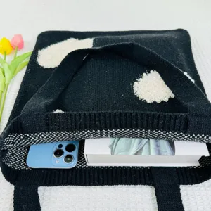Detailansicht der schwarzen Strick-Tasche mit fluffigen Herz-Mustern und geräumigem Innenraum.