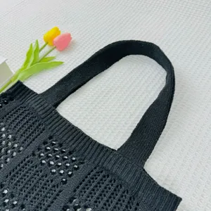Detailansicht der schwarzen Strick-Tote-Bag mit hohler Textur und Schulterriemen.
