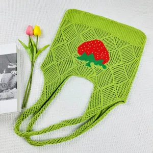 Grüne Strick Erdbeere Tragetasche Detail, mit einzigartigem Rautenmuster und süßem Frucht-Design.