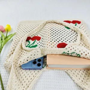 Vista detallada del bolso tote de punto con motivo de cereza, diseño estético.