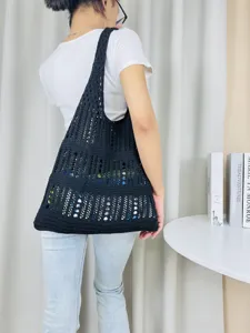 Schwarze Häkelstrick Schultertasche Detail, lässiger Sommer Strand Shopper Stil für Damen.
