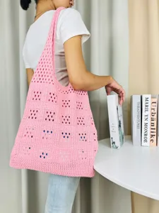 Nahaufnahme der rosa Strick-Hohl-Umhängetasche, lässiger Strandstil und geräumiges Design.