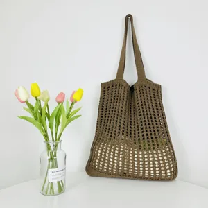 Detailaufnahme der braunen Häkelstrick-Tasche, Netz-Umhängetasche mit Blumen-Deko.