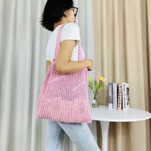 Detail view of pink knitted crochet tote bag showcasing hollow-out texture and large capacity.