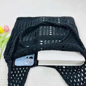 Nahaufnahme der schwarzen Strick-Hohl-Schultertasche mit feinem Netzmuster-Detail.