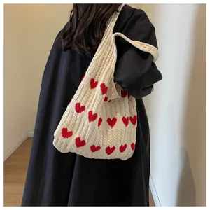 Detailansicht einer süßen Strick-Tasche mit roten Herzen und gemütlicher weicher Textur.