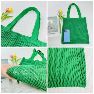 Green knitted tote bag detail view, hollow out shoulder bag weave pattern close up.