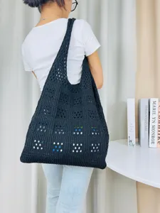 Detailansicht einer schwarzen, gehäkelten Schulter-Tragetasche mit Lochmuster für Damen.