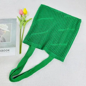 Green knit hollow tote bag detail, featuring mesh woven texture and comfortable shoulder strap.