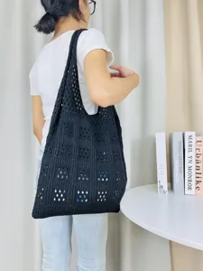Detailansicht einer schwarzen Strick-Netz-Umhängetasche, lässige hohle Strandhandtasche.