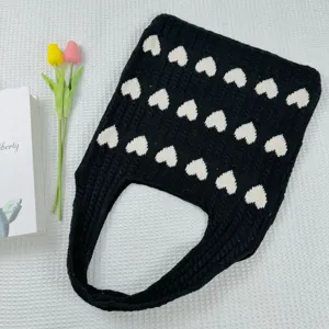 Schwarze Strick-Tasche mit weißem Herz-Muster Detail, lässige Handtasche für den Alltag.