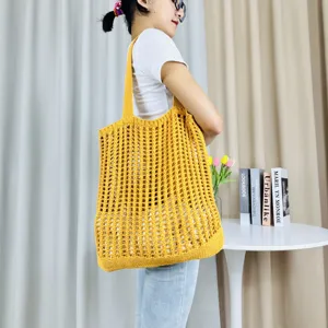 Gelbe geflochtene Häkel-Schultertasche Detailansicht zeigt feine Maschenstruktur und Design.