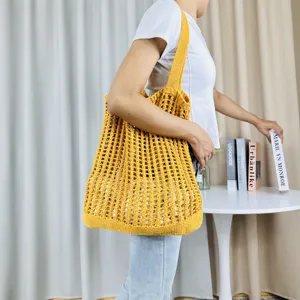 Detailansicht einer gelben gestrickten Schultertasche mit Lochmuster, ideal für den Alltag.