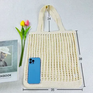 Detailansicht der beigen gestrickten Beuteltasche mit Lochmuster und Doppelgriffen.