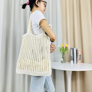 Beige gestrickte ausgehöhlte Schulter-Tote-Bag, lässige Strandtasche in Seitenansicht.