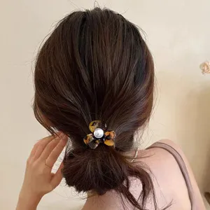 Tortoise shell acetate flower hair tie detail shot, showing the elegant pearl center design.