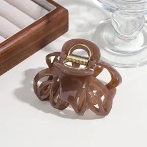 Detail shot of a brown hollow hair claw clip, simple daily hair accessory for thick hair.