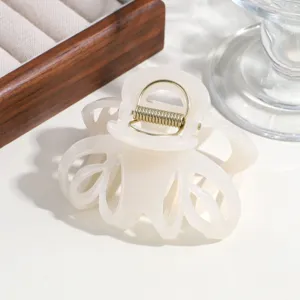 Detailed shot of a simple solid color hollow hair claw clip, elegant translucent design for thick hair.