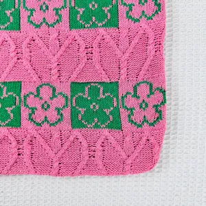 Detailed view of pink and green knitted floral tote bag fabric showing textured woven pattern.